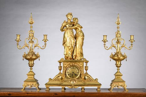 A gilt bronze clock 'ladies' by Houdebine with two candlesticks: A gilt bronze clock 'ladies' by Houdebine with two candlesticks