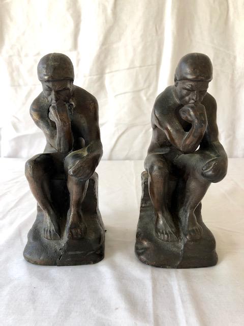 After Rodin "The Thinker" Statue Bookends: After Rodin "The Thinker" Statue Bookends Pair/Set of 2. Cast metal with a brass/bronze-like finish. Unsigned, unmarked or stamped. Each 3 1/4" by 3 1/4" base, 8" tall.