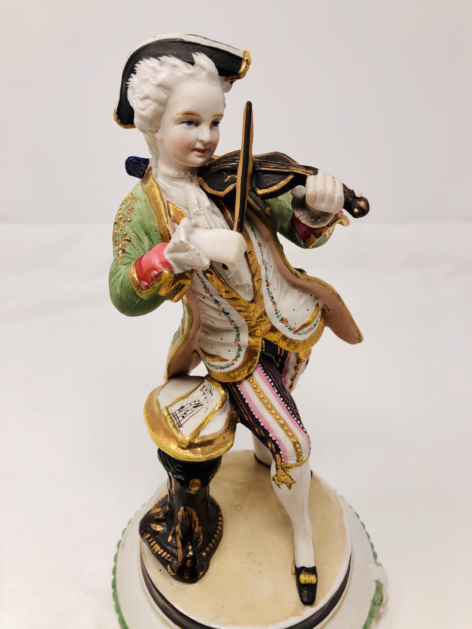 French Colonial Man Playing Violin Porcelain Figurine: French Colonial Man Playing Violin Porcelain Figurine. Unmarked. Approx. 9-inches Tall. 5-inch Diameter Base. Note all pictures As-is, as-shown.