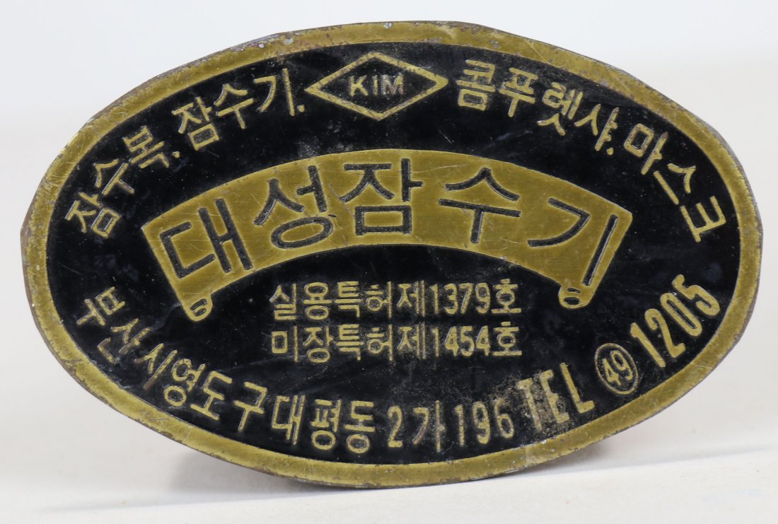 KIM Diving Helmet Breastplate ID Brass New Old Stock: This is a new old stock (never used) brass ID plate for a KIM diving helmet. KIM was located in South Korea and in some cases these ID plates are missing from heavy use and wear. Measures 2-1/2 inches