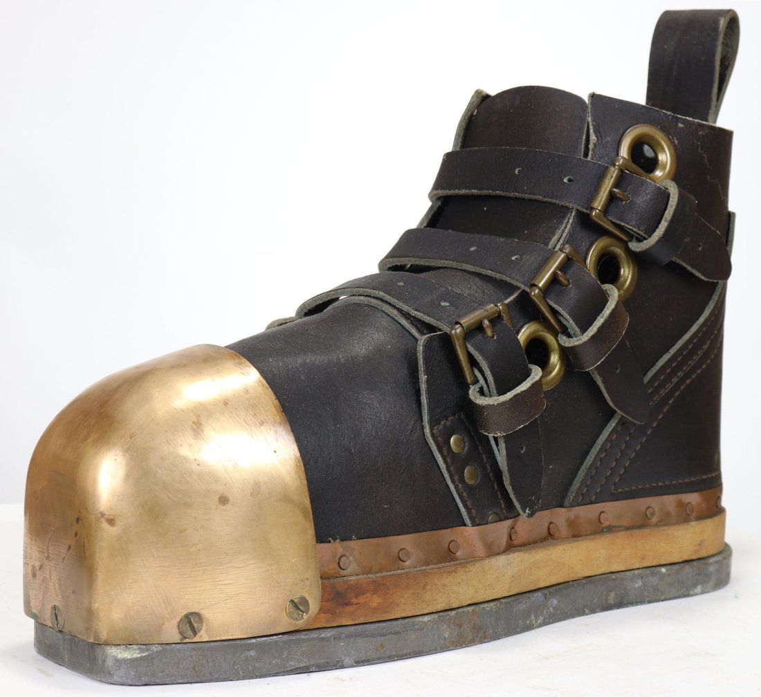New Old Stock US Navy Mark V Leather, Brass & Lead Boot: A single dive boot in excellent new old stock condition. Unmarked, the boot features a leather body and straps, brass grommet holes and buckles, brass toe, wood inner sole and smooth lead bottom. Boot