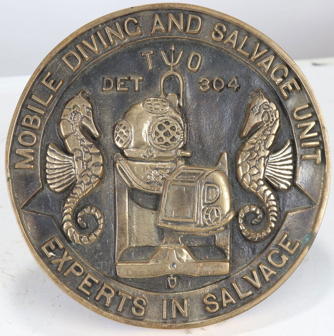 Brass Mobile Diving & Salvage Unit Mark V & 12 Plaque: Impressive cast brass plaque for the Mobile Diving and Salvage Unit: DET 304: Experts In Salvage. Great images of Mark V and Mark 12 diving helmets! This piece measures 7-3/8 inches round. Has two bra