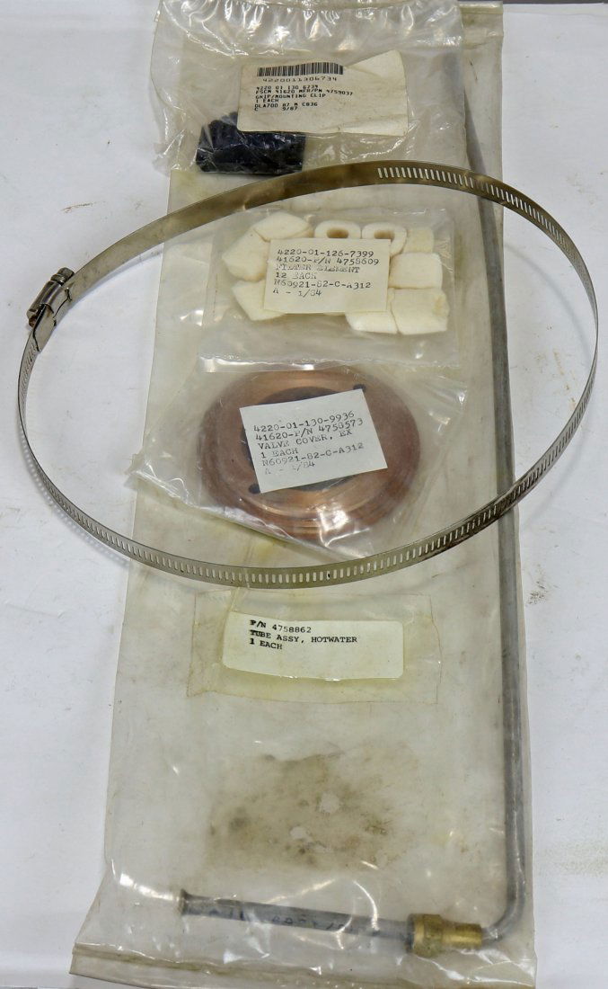 US Navy Mark 12 Diving Helmet Parts Grouping: This is a small grouping of new old stock replacement parts for the Mark 12 diving helmet. The items are a stainless steel neck ring band, brass valve cover, hotwater tube assembly, package of 12 filt