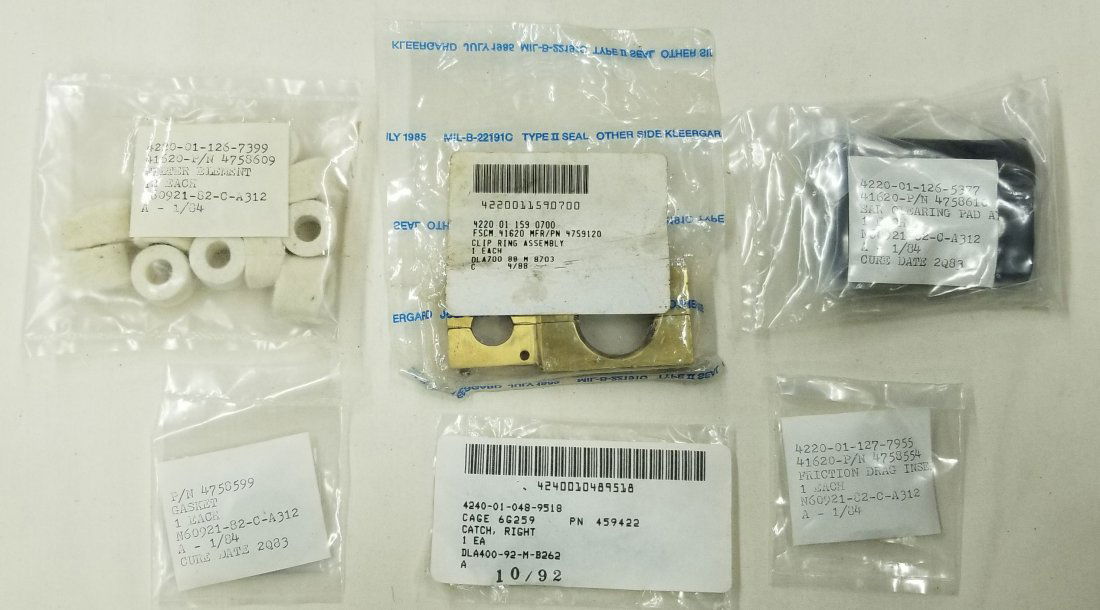 Mark 12 Diving Helmet Assorted NOS Parts Lot #2: Lot of 6 sealed packs of various Mark 12 diving helmet parts. Filter elements, brass clip ring assembly, ear clearing pad, friction drag insert, cage catch, gasket. Items are all new old stock (NOS).