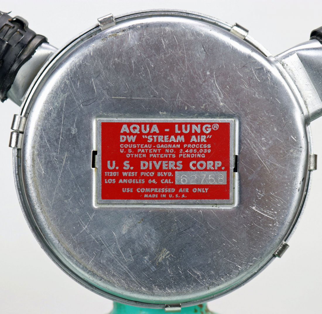Aqua-Lung DW Stream Air 1956 Red Label Double Hose Reg: Good example of a US Divers Aqua-Lung DW Stream Air double hose regulator. This piece dates to the 1956 to 1957 time period. A clear red label is intact with serial number 62758 and West Pico Blvd. ad