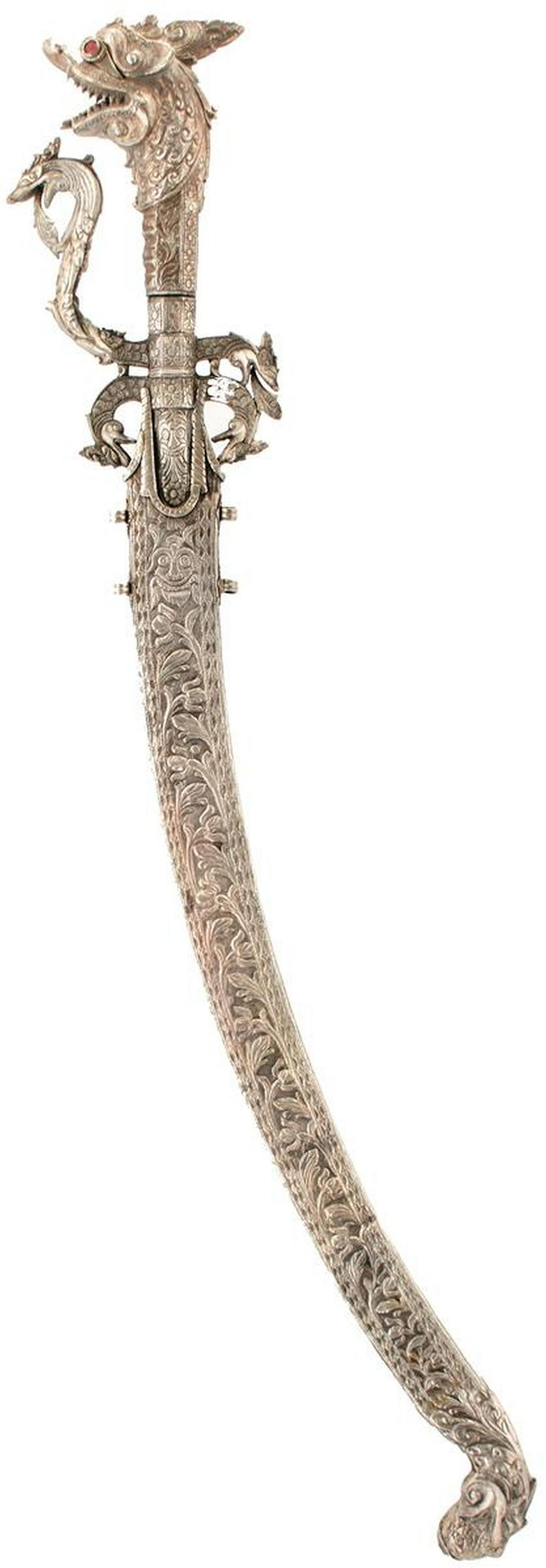 A SINHALESE OR CEYLONESE KASTANE OR SHORT SWORD: A SINHALESE OR CEYLONESE KASTANE OR SHORT SWORD, 36cm curved blade with faceted back edge, inlaid in brass and chiselled with a geometric design, characteristic white metal hilt decorated with scrolli