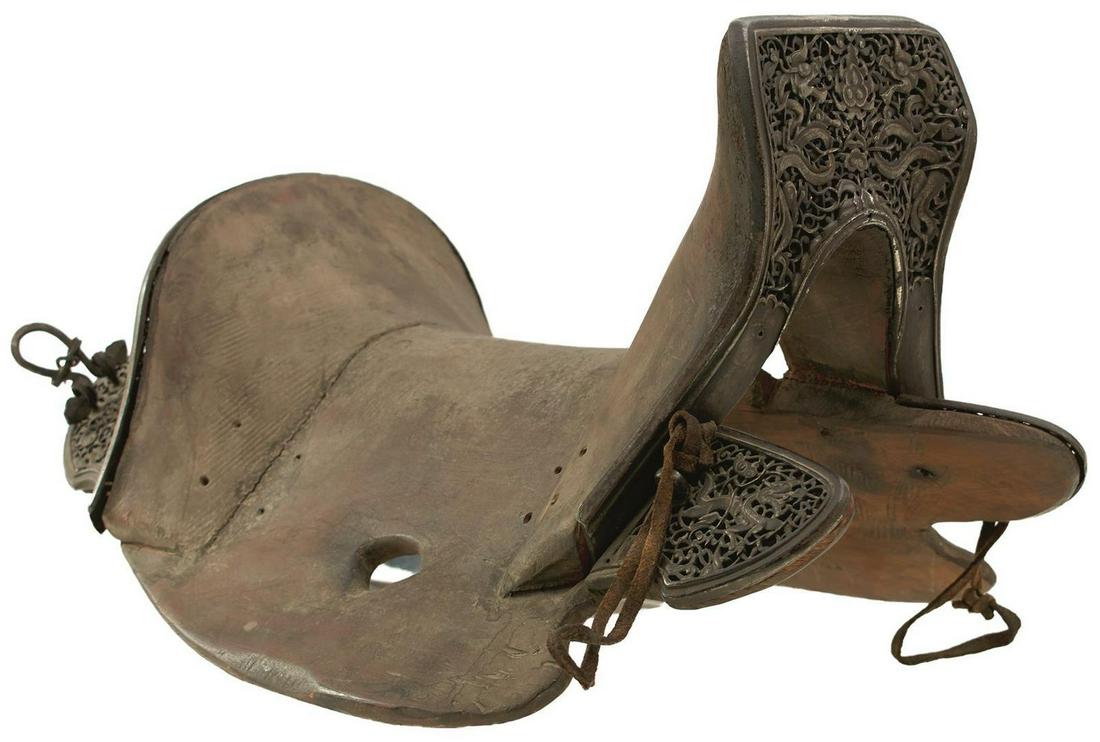 A RARE 17TH OR 18TH CENTURY TIBETAN SADDLE: A RARE 17TH OR 18TH CENTURY TIBETAN SADDLE, constructed with a wooden tree, the pommel and cantle with pierced iron plates with traces of silver and gilt and decorated with scrollwork and dragons guar
