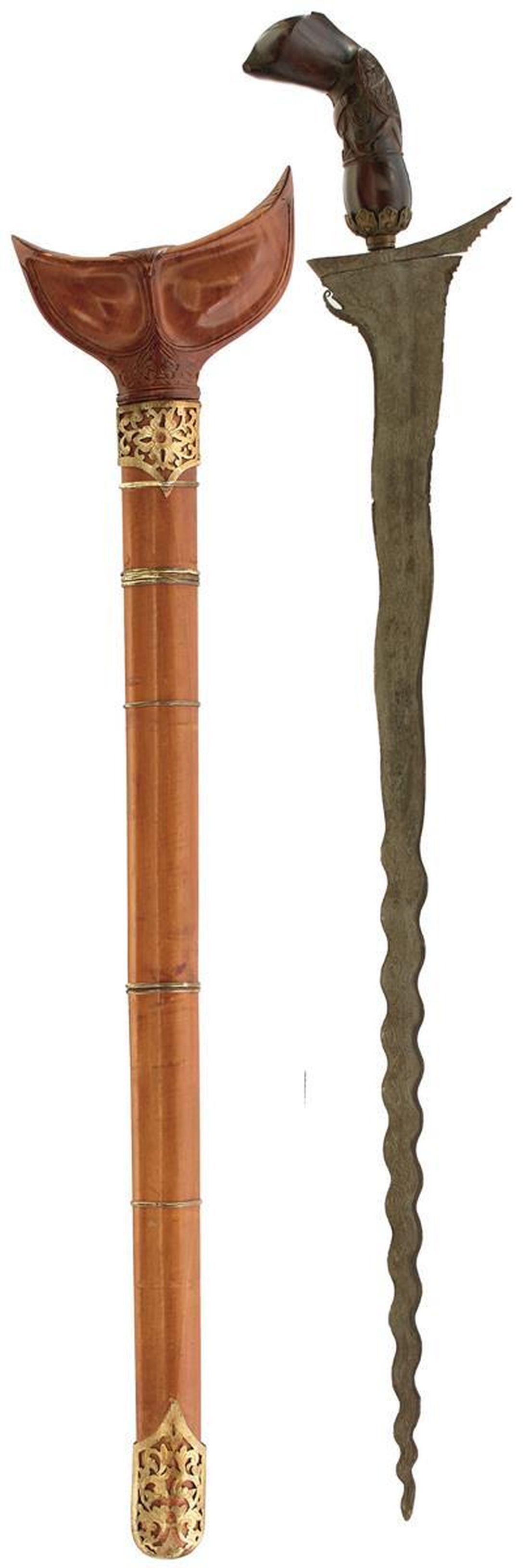 A LARGE LATE 19TH OR EARLY 20TH CENTURY MALAYAN EXECUTIONER'S KRIS: A LARGE LATE 19TH OR EARLY 20TH CENTURY MALAYAN EXECUTIONER'S KRIS, 57.5cm double fullered wavy watered steel blade, characteristic carved wooden hilt with filigree collar, contained in its pierced co