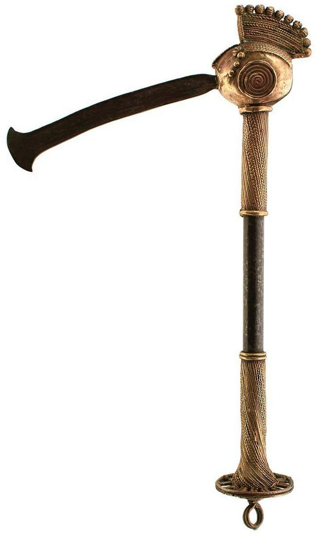 AN AFRICAN NIGERIAN CEREMONIAL PARADE AXE: AN AFRICAN NIGERIAN CEREMONIAL PARADE AXE, early 20th Century, iron and brass, the blade emanating as a tongue from the brass ceremonial head, 43cm long. For a similar piece see the Pitt Rivers Museum
