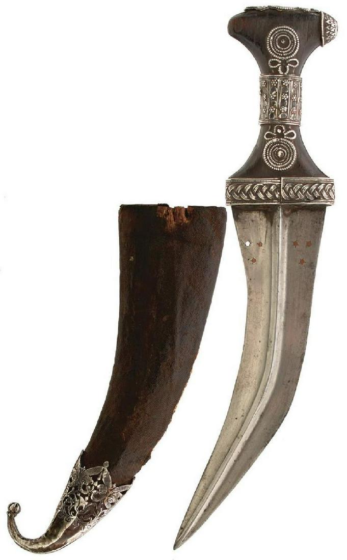 A 19TH CENTURY INDIAN JAMBIYA, 21cm angular curved blade with bold raised medial ridge and pierced: A 19TH CENTURY INDIAN JAMBIYA, 21cm angular curved blade with bold raised medial ridge and pierced with stars set with brass at the forte, one insert lacking, characteristic white metal mounted wooden