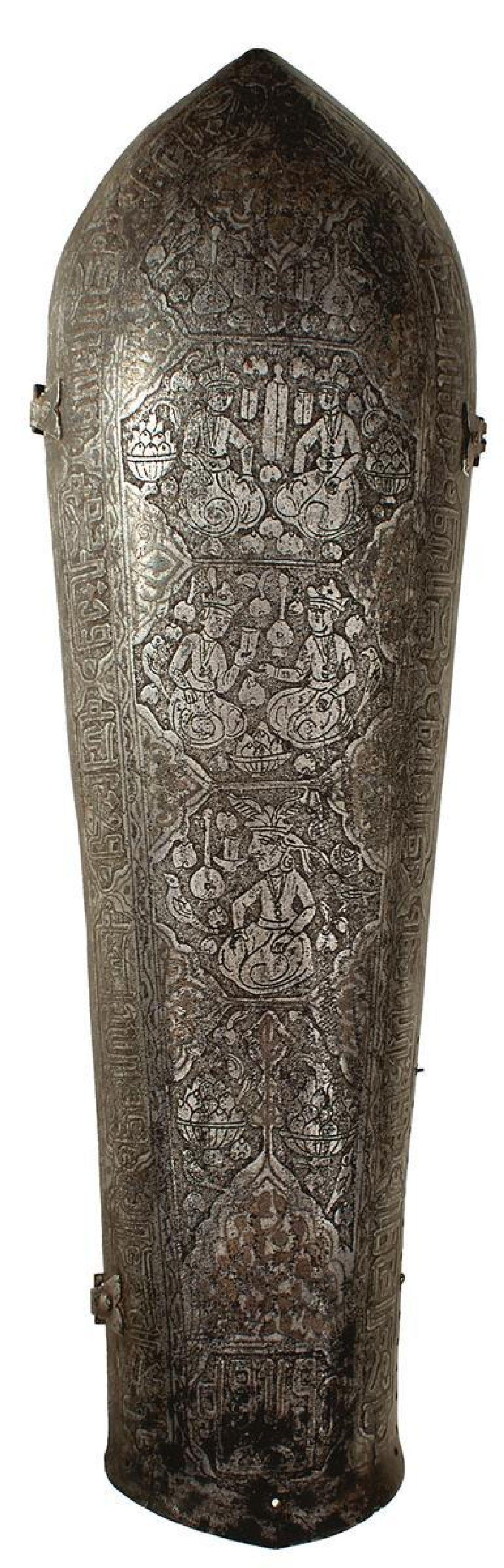 A QAJAR DYNASTY PERSIAN BAZUBAND OR ARM DEFENCE, of characteristic form, etched with a border of: A QAJAR DYNASTY PERSIAN BAZUBAND OR ARM DEFENCE, of characteristic form, etched with a border of stylised calligraphy and panels of courtly scenes and figures along its length, old Wallis & Wallis lab