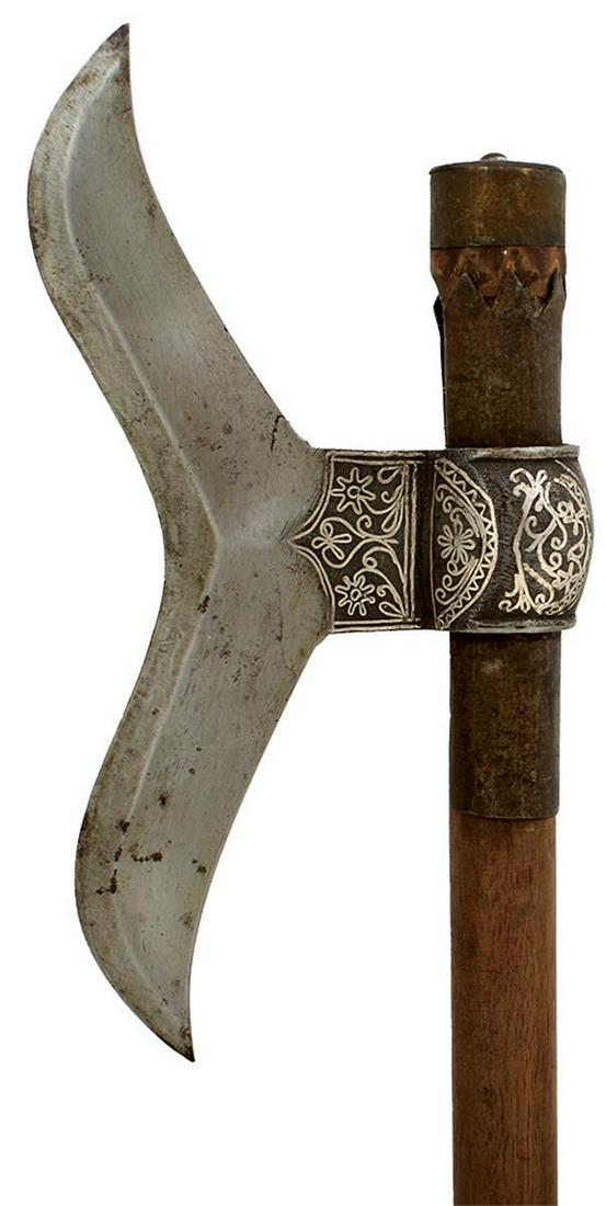 A GOOD QUALITY 19TH CENTURY INDIAN AXE, 22cm polished iron moustache-shaped head lateral ridge,: A GOOD QUALITY 19TH CENTURY INDIAN AXE, 22cm polished iron moustache-shaped head lateral ridge, socket thickly damascened with silver, mounted on its wooden haft with iron reinforcing band and brass p