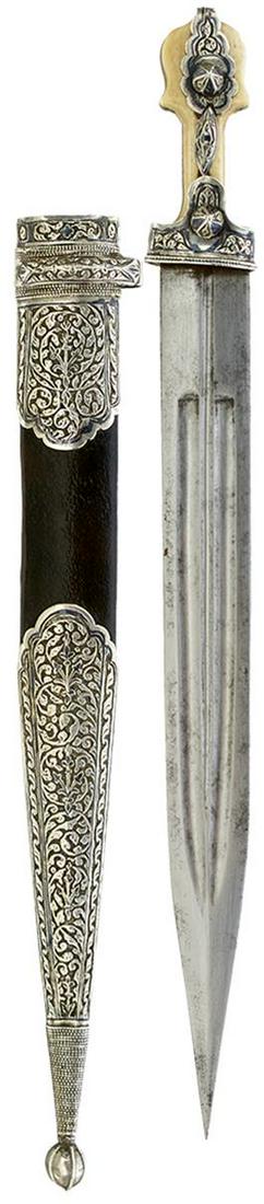 A 19TH CENTURY CAUCASIAN KINDJAL, 32cm triple fullered blade, characteristic hilt with foliate: A 19TH CENTURY CAUCASIAN KINDJAL, 32cm triple fullered blade, characteristic hilt with foliate embossed silver niello mounts, two-piece walrus ivory grips, one chipped, contained in its silver niello