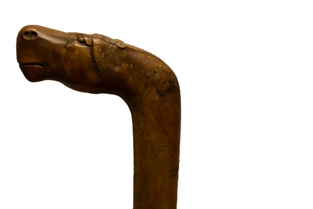 A BOER WAR PERIOD WALKING STICK, the wooden haft with carved wooden handle in the form of a horse's: A BOER WAR PERIOD WALKING STICK, the wooden haft with carved wooden handle in the form of a horse's head and incised Kepkypa, together with another Zulu (?) the handle carved in the form of a shoe. (2