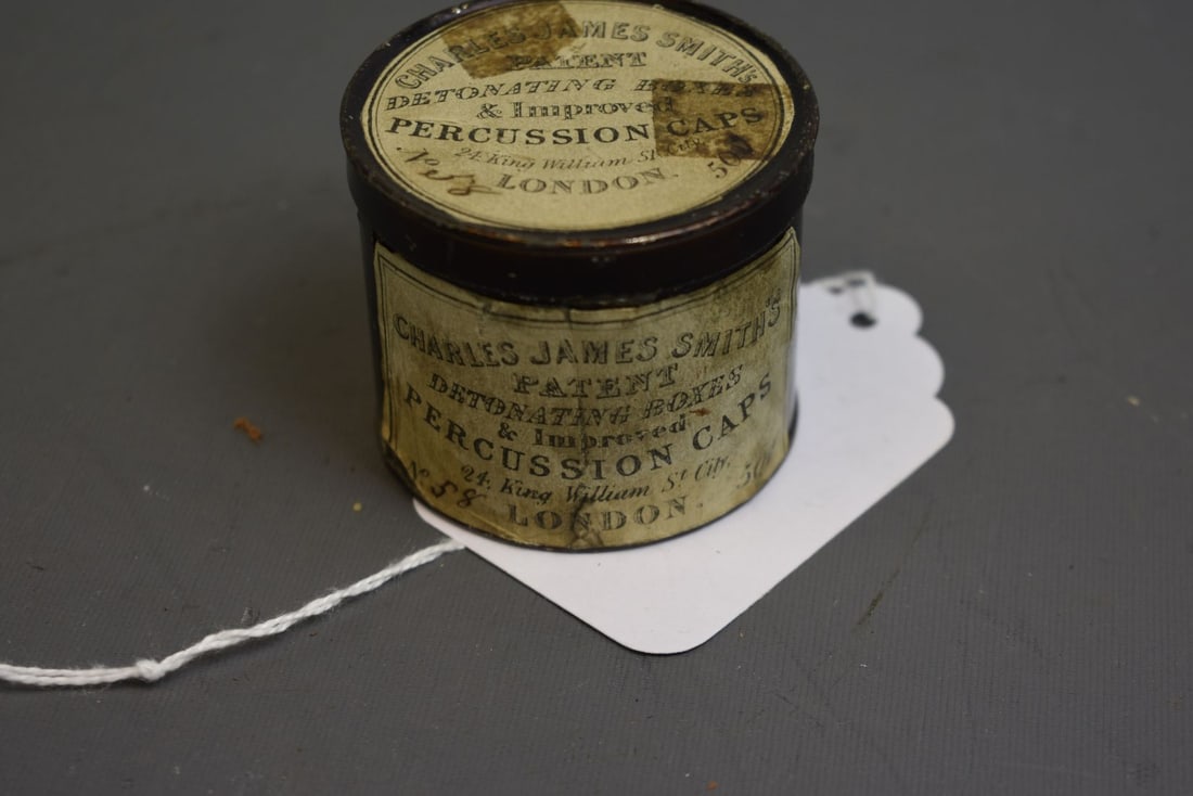 A LARGE TIN OF PERCUSSION CAPS,: A LARGE TIN OF PERCUSSION CAPS, the japanned body applied with maker's trade labels to the body and lid for CHARLES JAMES SMITH.