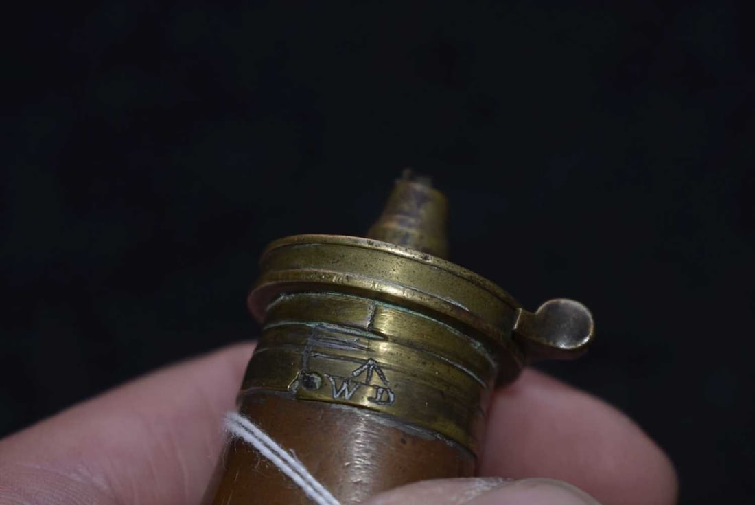 A COLT FLASK FOR THE PATTERN 1851 NAVY MODEL,: A COLT FLASK FOR THE PATTERN 1851 NAVY MODEL, 13cm high, the top side engraved with broad arrow and WD, the top flat marked Dixon & Sons Patent. Top of spout broken and spring missing. A rare variant,