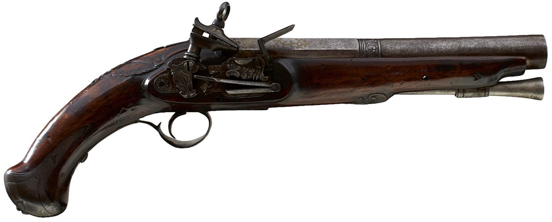 AN 18TH CENTURY .700 CALIBRE SPANISH OFFICER'S MIQUELET LOCK PISTOL,: AN 18TH CENTURY .700 CALIBRE SPANISH OFFICER'S MIQUELET LOCK PISTOL, 8inch two-stage barrel chiselled with a band of foliage at the midpoint and inlaid in yellow metals with scrolling foliage, fleurs 