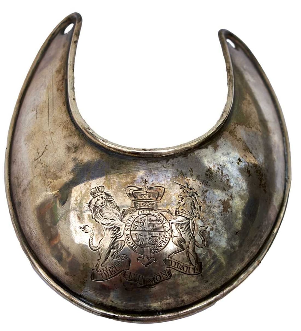 A GEORGIAN UNIVERSAL PATTERN IRISH (?) MILITIA GORGET,: regulation white metal body engraved with the Royal arms, turned edges, pierced on the arms for suspension silk, hammered to the reverse, tests as silver. A label attached proposes it was by or for Ir