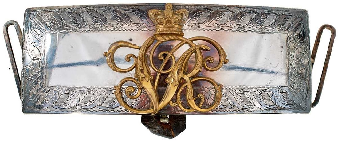 A VICTORIAN SHOULDER BELT POUCH,: A VICTORIAN SHOULDER BELT POUCH, the white metal flap with scrolling foliate engraved border and applied with a gilt metal crown over VR cypher, leather covered wooden body, belt loops.