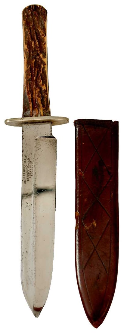 A SMALL BOWIE KNIFE BY GEORGE BUTLER,: 15.25cm spear tipped blade stamped GEORGE BUTLER & CO. TRINITY WORKSHOPS SHEFFIELD ENGLAND, shaped nickel crossguard, two-piece riveted natural stag?s horn grips in its leather sheath. Good polish