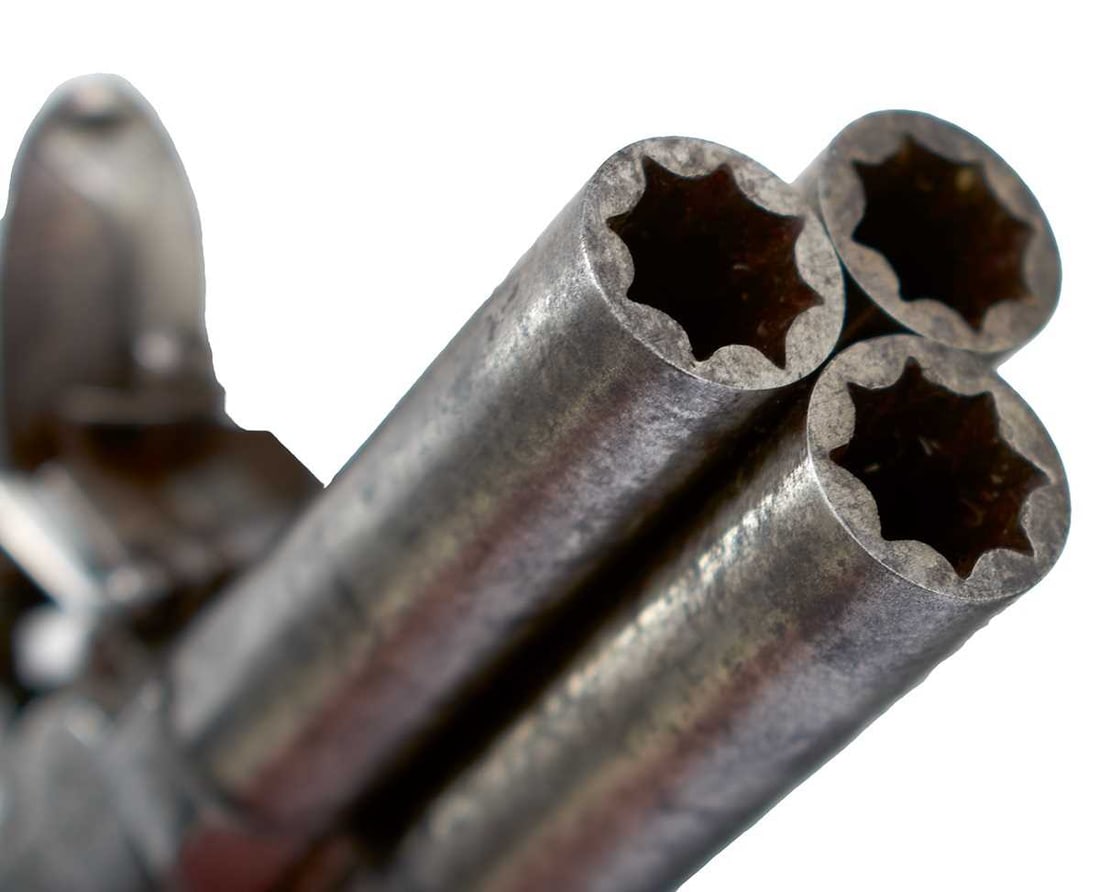 A SCARCE 122-BORE FLINTLOCK BOXLOCK TRIPLE BARRELLED MUFF OR POCKET PISTOL BY DUNDERDALE & MABSON,: 1.75inch turn-off barrels, border engraved signed action decorated with stands of arms, the tap mounted on the left side, sliding safety, slab-sided wooden butt.