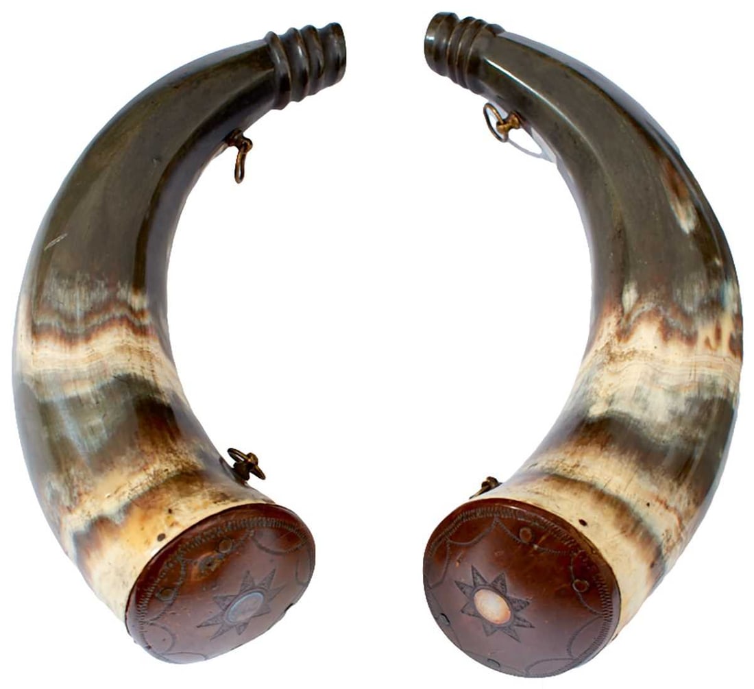 A SCARCE PAIR OF FINE QUALITY SMALL POWDER HORNS,: 9in long, decorated end plugs with small white metal blank escutcheons, faceted towards the turned tips and with small oblong bone blank escutcheons, two carrying rings. When suspended from the rings