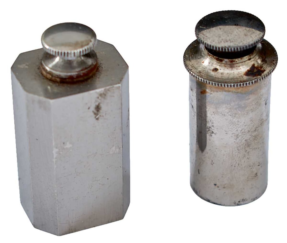 A BRACE OF BURNISHED OIL BOTTLES,: the first 4.2cm high and of cylindrical form, the second 4.4cm high and of rectangular form. (2)