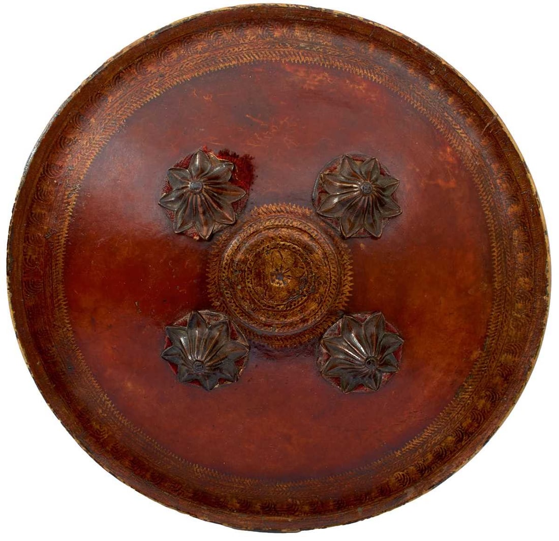 A LATE 18TH OR EARLY 19TH CENTURY TRANSLUCENT INDIAN DHAL OR SHIELD,: the 31.5cm diameter domed body with turned rim, decorated to the border with bands of geometric designs and scrolling foliage in gilt, central circular gilt panel decorated to match and chased with