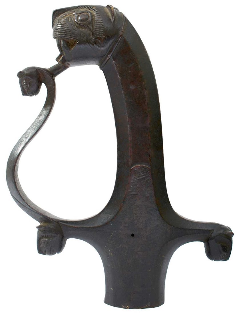 A RARE TIPU SULTAN MACE, BULLOVA OR PHARASA HILT,: circa 1790, the cast bronze hilt with bold, open mouthed Tiger's head pommel, decorated with bubri, plain faceted grip, the scroll knuckle guard with Tiger's head terminal, the quillons with matching