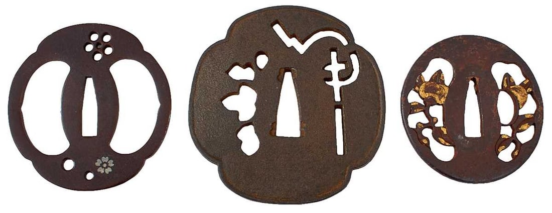 THREE IRON SUKASHI TSUBA,: the first pierced with opposing crescent forms and a flower form, soft metal flowerheads and tendril, the second pierced with vines and flowerheads and with yellow metal highlights, the largest of