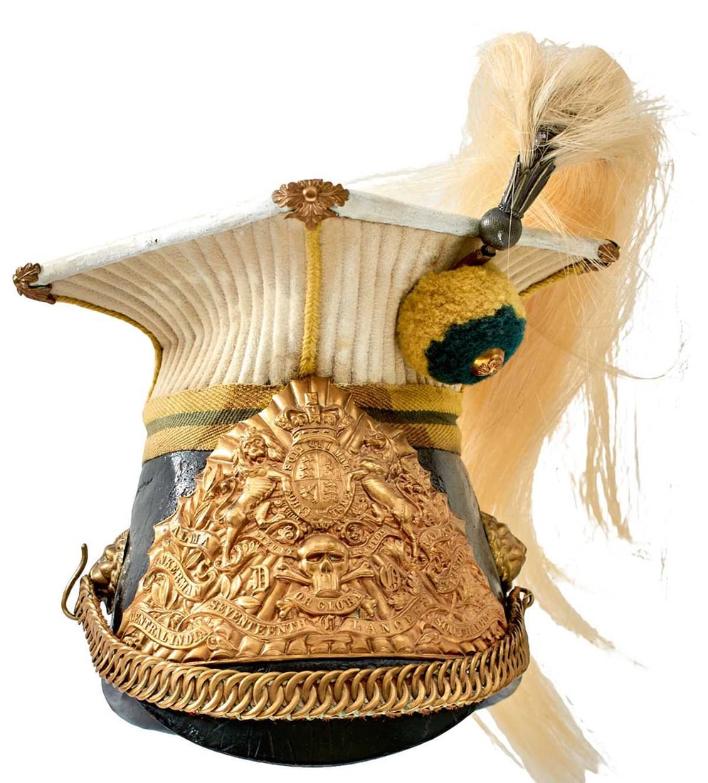 A VICTORIAN TROOPER'S LANCE CAP OF THE 17TH LANCERS,: the black leather skull with painted white leather top and quilted white cloth support, green and yellow cloth band, green and yellow woollen pompom with regimental button, white metal plume holder wi