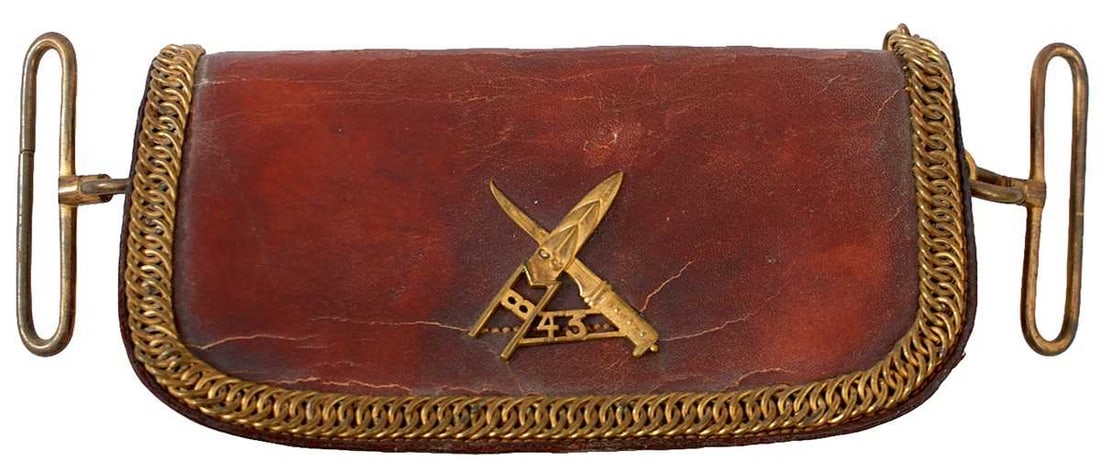 AN INDIAN ARMY 43RD ERINPURA REGIMENT SHOULDER BELT POUCH,: the brown leather body applied to the flap with the gilt brass regimental device, crossed Katar and Peshkabz over pierced 43, applied gilt chain border, brass suspension rings, red painted tin liner.
