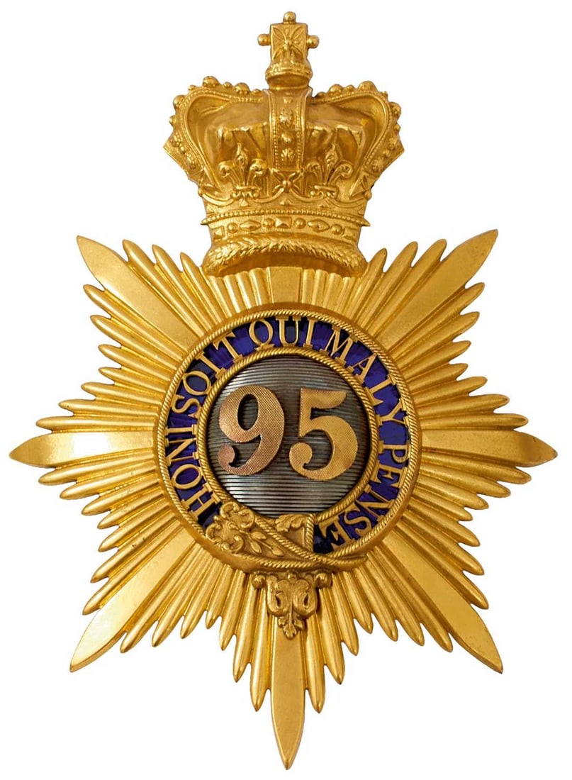 A 95TH (DERBYSHIRE) REGIMENT OFFICER'S SHAKO PLATE,: gilt metal faceted rayed star surmounted by a crown, central HONI SOIT QUI MAL Y PENSE in a strap on a blue enamel ground, centred by 95 on an engine turned grey metal ground.
