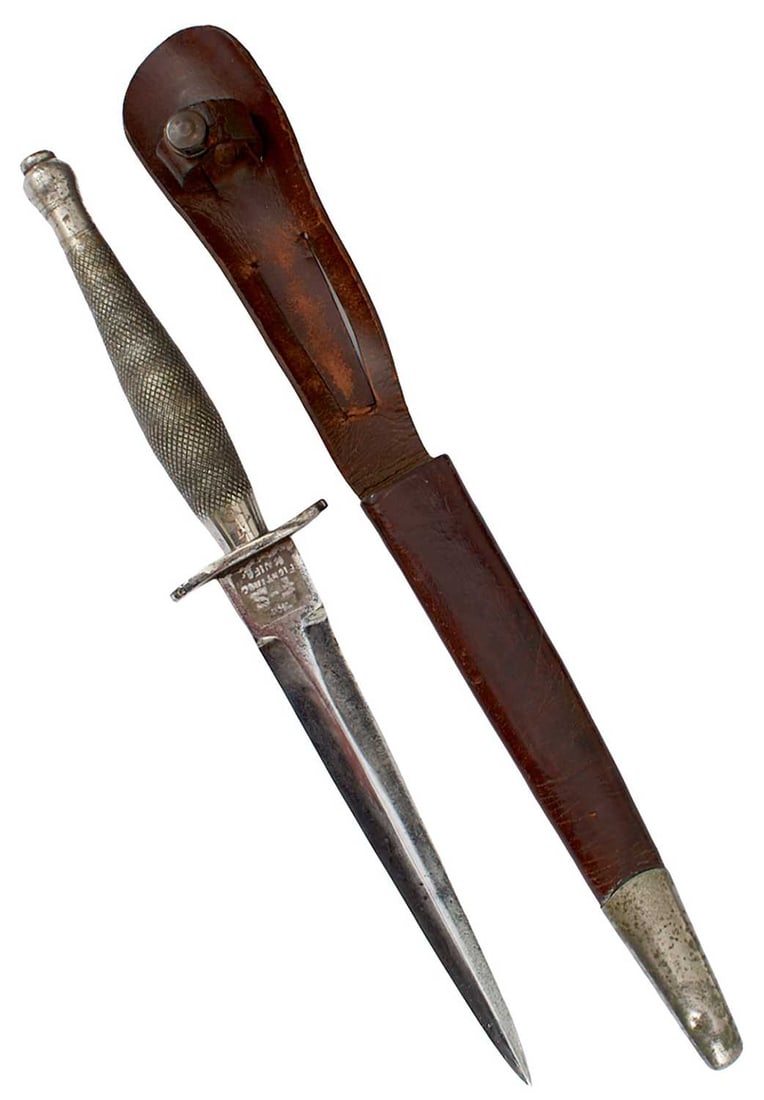 A FIRST PATTERN COMMANDO KNIFE OR DAGGER,: 16.4cm flattened diamond section blade etched with the F-S and Wilkinson panels to either side of the forte, regulation plated hilt with recurved guard and chequered grip, in its plated mounted