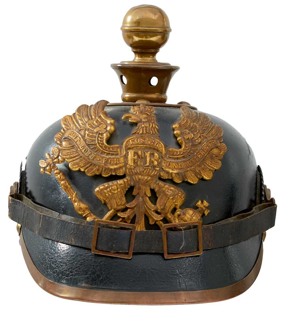 A PRUSSIAN OTHER RANKS ARTILLERY PICKELHAUBE,: the black leather skull with brass fittings, ball, Prussian eagle helmet plate, ball finial, Imperial and State cockades, leather chin strap, leather liner, pencil marked with owner's name Sabwchak