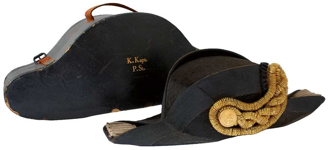 A SCARCE IMPERIAL GERMAN NAVAL OFFICER'S BICORN HAT,: the fur covered black body with plain ribbon trim, bullion rank insignia with gilt Kriegsmarine button, leather head band, cream silk lining, in its yellow cloth lined black cloth covered cardboard