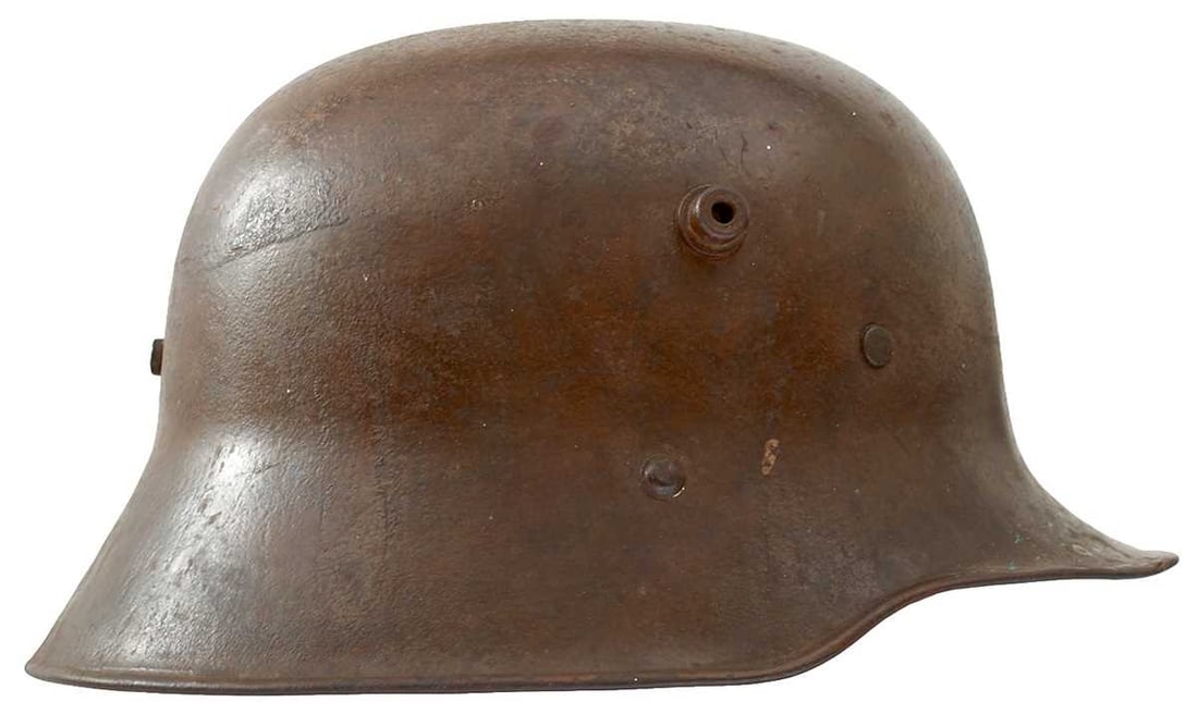 A FIRST WAR PERIOD GERMAN HELMET,: the steel skull with traces of original brown coloured painted finish and maker stamped L101 to the top and AW64 to the inside remains of padded line and canvas chin strap. Originally found with Lot 8