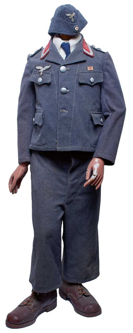 A SCARCE LUFTWAFFE FLAK OPERATOR'S UNIFORM FOR A CHILD,: the regulation grey/blue cloth jacket and trousers with stippled alloy buttons, cloth unit insignia, complete with shirt, tie and boots, mounted on a period mannequin. Believed to have formed part of