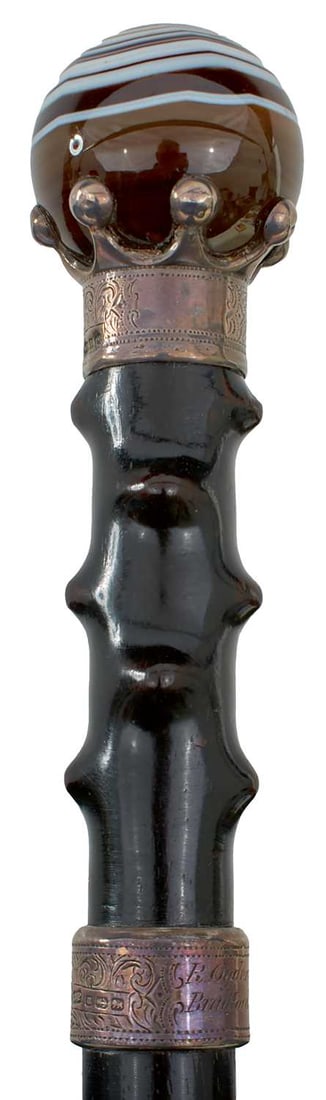 AN EARLY 20TH CENTURY SWORD STICK,: 63.5cm triangular section blade etched with foliage, the spherical agate pommel encased in silver mount and foliate collar hallmarked for Birmingham 1911 with maker's mark J.P, ebonised briar-carved