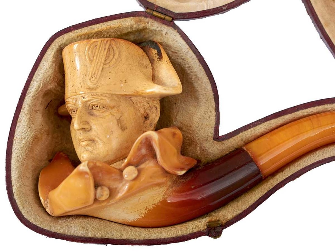 A 19TH CENTURY MEERSCHAUM PIPE IN THE FORM OF NAPOLEON BONAPARTE,: the bowl in the form of the head and shoulders of Napoleon, amber mouthpiece, 17cm long, in fitted case (damaged).