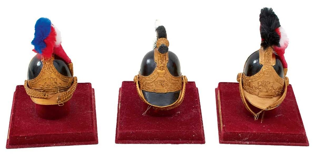 THREE VARIOUS MODERN MINIATURE HELMETS,: Life Guards, Dragoon Guards and Horse Guards, each with stand. (3)