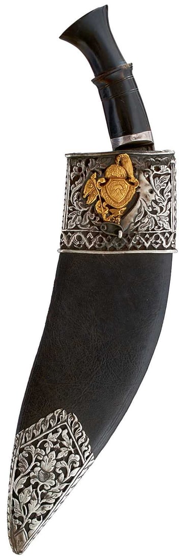A 19TH CENTURY WHITE AND YELLOW METAL MOUNTED NEPALESE KUKRI,: A 19TH CENTURY WHITE AND YELLOW METAL MOUNTED NEPALESE KUKRI, 32.5cm sharply curved fullered broad blade, characteristic hilt with carved horn grip, in its white metal mounted leather wrapped wooden s
