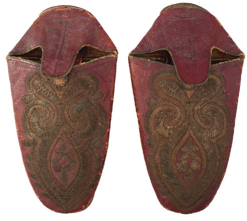 A PAIR OF 19TH CENTURY TURKISH OR OTTOMAN EMBROIDERED SLIPPERS,: A PAIR OF 19TH CENTURY TURKISH OR OTTOMAN EMBROIDERED SLIPPERS, each of stitched red Morocco leather embroidered with a stylized fleur de lys, leather soles, one inscribed and numbered 269. (2)