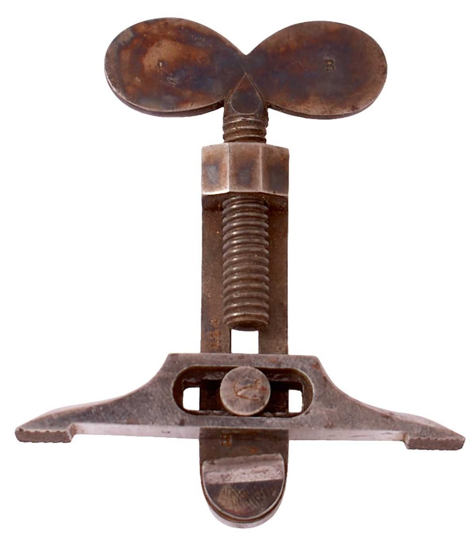 A 19TH CENTURY MAIN SPRING CLAMP,: A 19TH CENTURY MAIN SPRING CLAMP, the case colour hardened body with butterfly top, stamped B, burnished steel jaws.