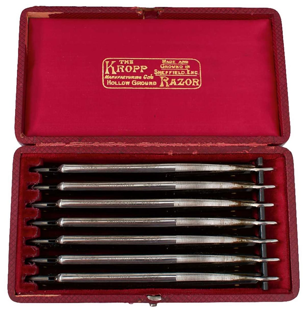 A DAY OF THE WEEK RAZOR SET,: A DAY OF THE WEEK RAZOR SET, 11cm hollow ground blades by The Kropp Manufacturing Company of Sheffield, celluloid grip scales, in their red velvet lined case.