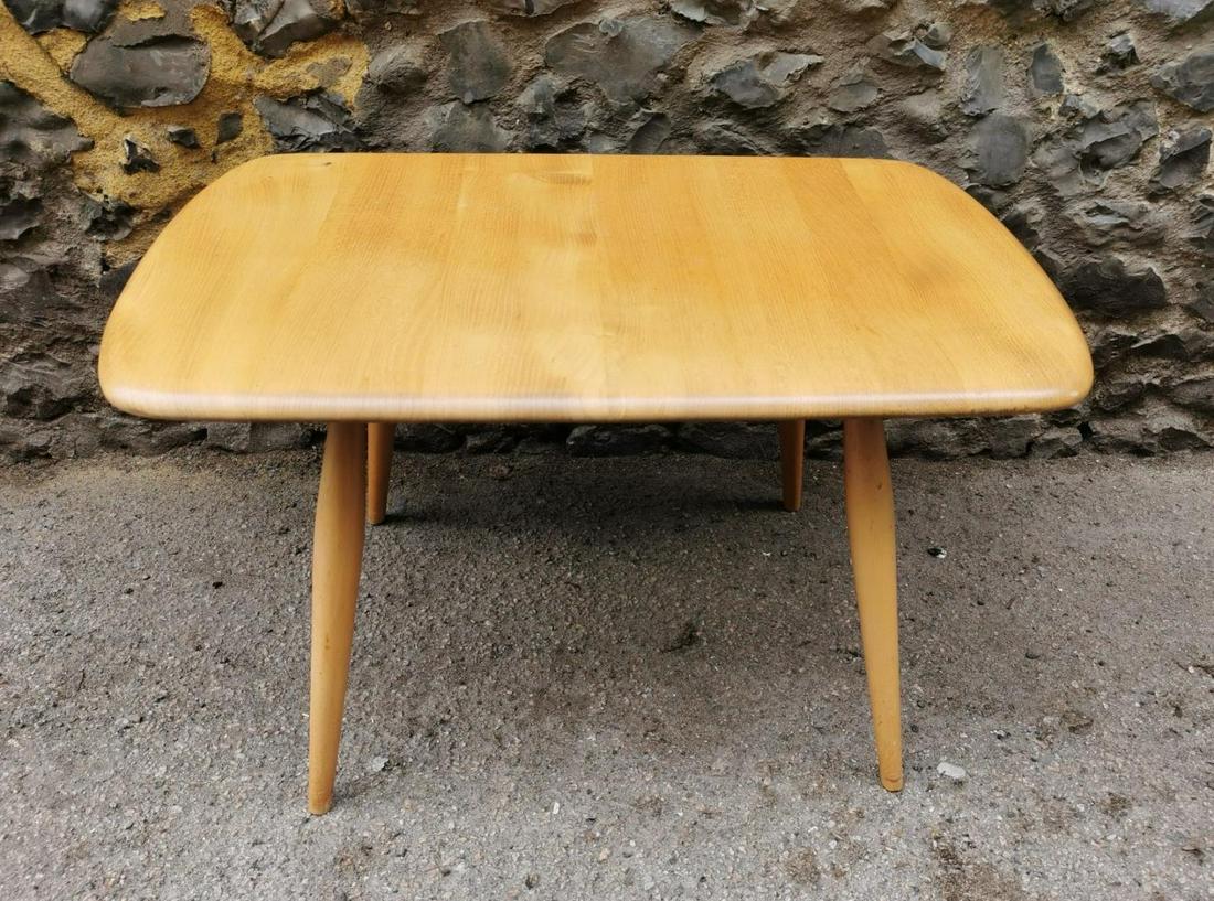 A small blonde elm Ercol design side table, of: A small blonde elm Ercol design side table, of rectangular form with four turned legs, 69 cm wide x 43 cm high