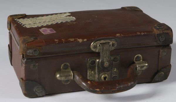 Louis Vitton Style Children's Suitcase: Circa 1909, leather with brass lock and bindings, 4"H x 10"W x'6.5"D. There is wear throughout consistent with age and normal use.