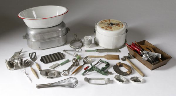 Extensive Collector's Lot Of Kitchen Related Arti: Including whips, graters, cheese cutters, ladles, large roasting pan, sausage grinder, vintage corn mold, and variety of other vintage items, together with a wood carrier. Wear consistent with normal