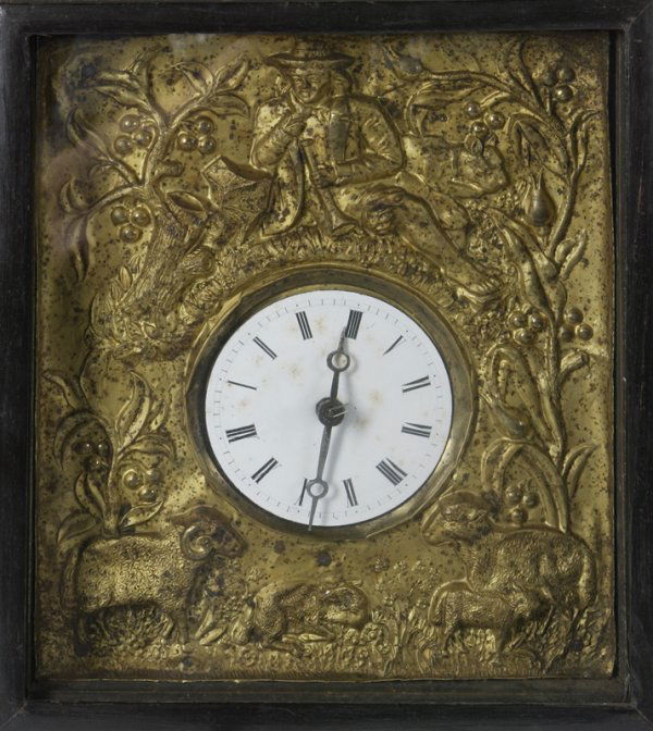 19th C. Wall Clock With Brass Works Housed In Wood: Carved wood frame with hammered brass panel with a colonial man wearing a hat holding a horn with berry and leaf designs and a ram with sheep, roman numeral dial, maker unknown, measures approximately