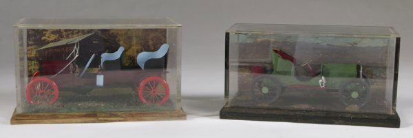 2-20th C. Model Cars in Plexiglas Cases: First is of a 1909 Ford; 5.5" H x 9.5" W x 5.5" D. The second is probably a Stutz,; 5.25" H x 10" W x 5" D. Both are hand painted and come in a decorated case with background and road scenes, mounted